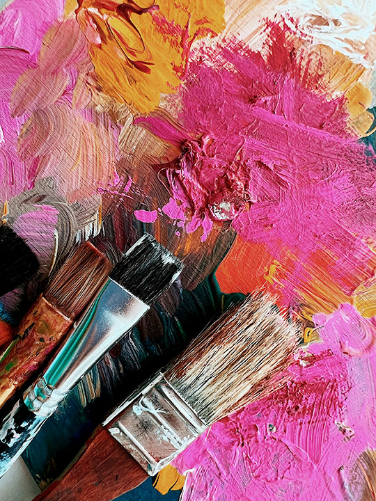 Paintbrushes on a pink palette